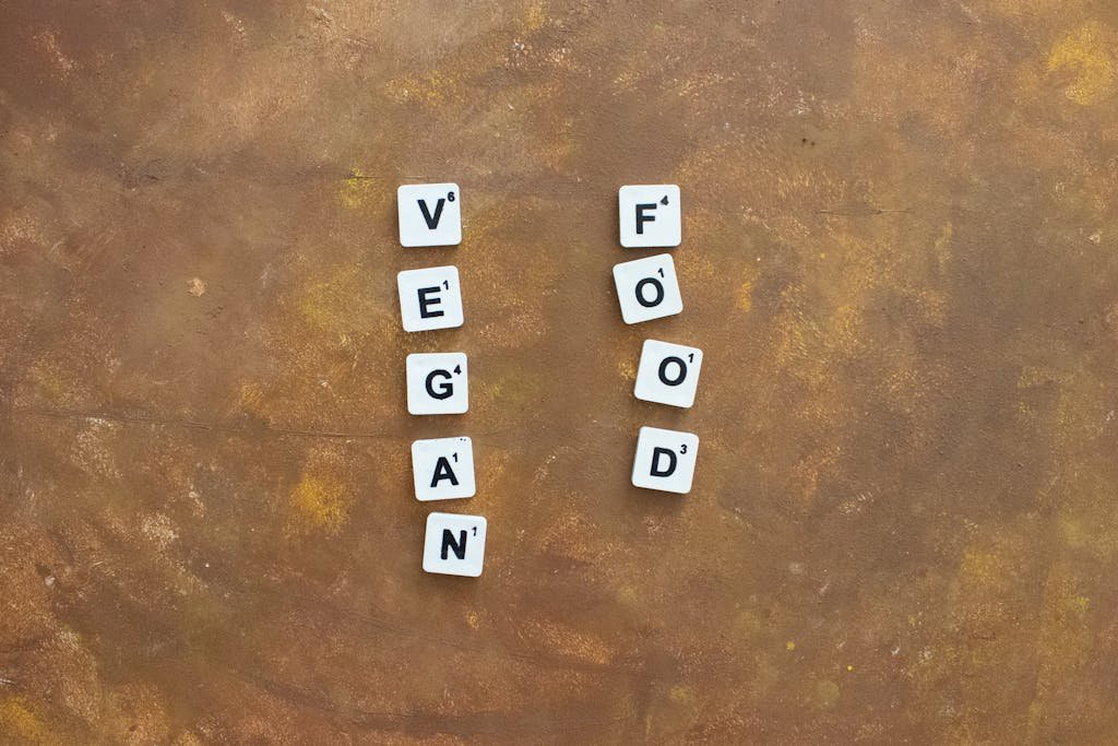 WellHealthOrganic concept of vegan food using letter tiles on a textured background.