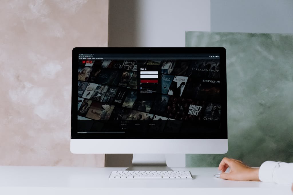 A modern desktop displays ClickUp Login a streaming service interface, showcasing entertainment options in a minimalist office setting.