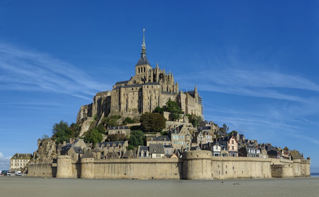 AWalter view of Mont Saint-Michel's historic island and abbey under a clear blue sky.