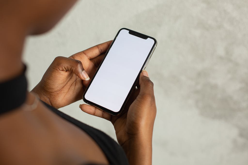 Mobile Apps and Tech Reviews Hub holding a smartphone with a blank screen, ideal for mock-ups and design.