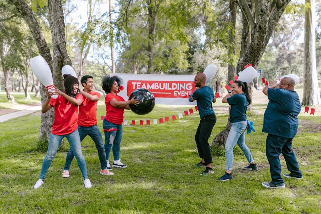 ClickUp manage teams building activity with diverse group playing in the park.