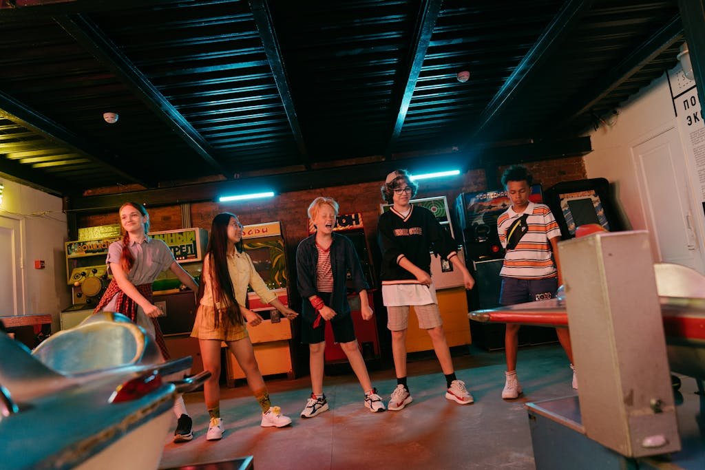 A group of teenagers enjoying their time together in a retro arcade with neon lights.