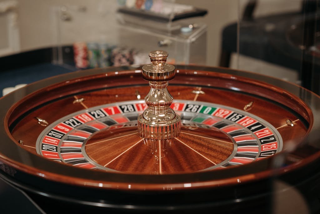 Close-up of a classic roulette wheel in a casino setting showcasing the elegant wooden design. 277bet.com