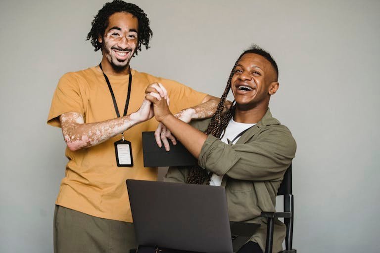 Happy Business Cards coworkers enjoying a moment of connection and positivity in a studio setting with laptops.
