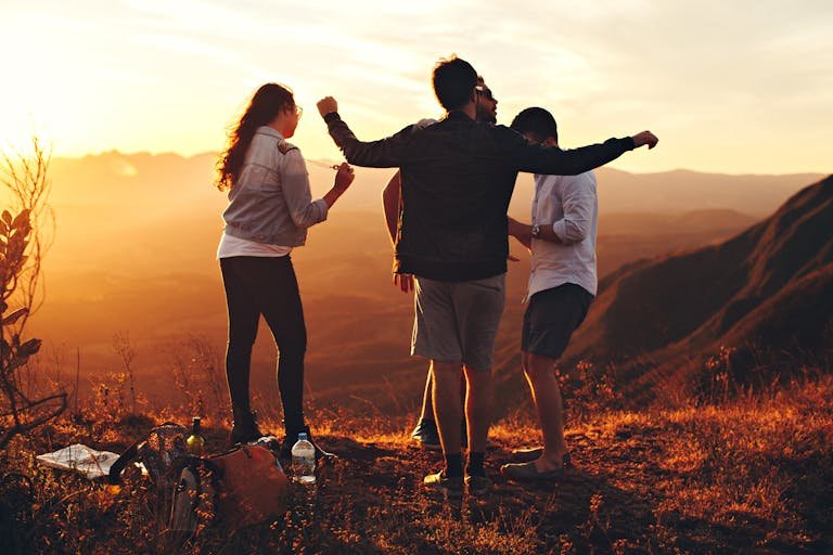 Joyful group of young adults enjoying a sunset view in a You Have Turned My Mourning Into Dancing Lyrics landscape in Brazil.