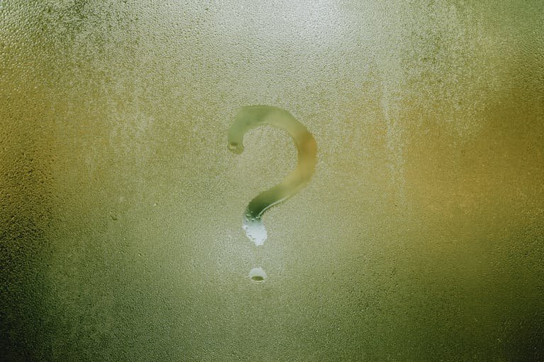 A Seekde mark drawn on foggy glass, evoking curiosity and mystery.