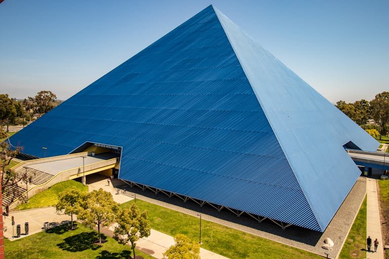 A Walter Retirement urban pyramid structure with blue exterior and lush surroundings.
