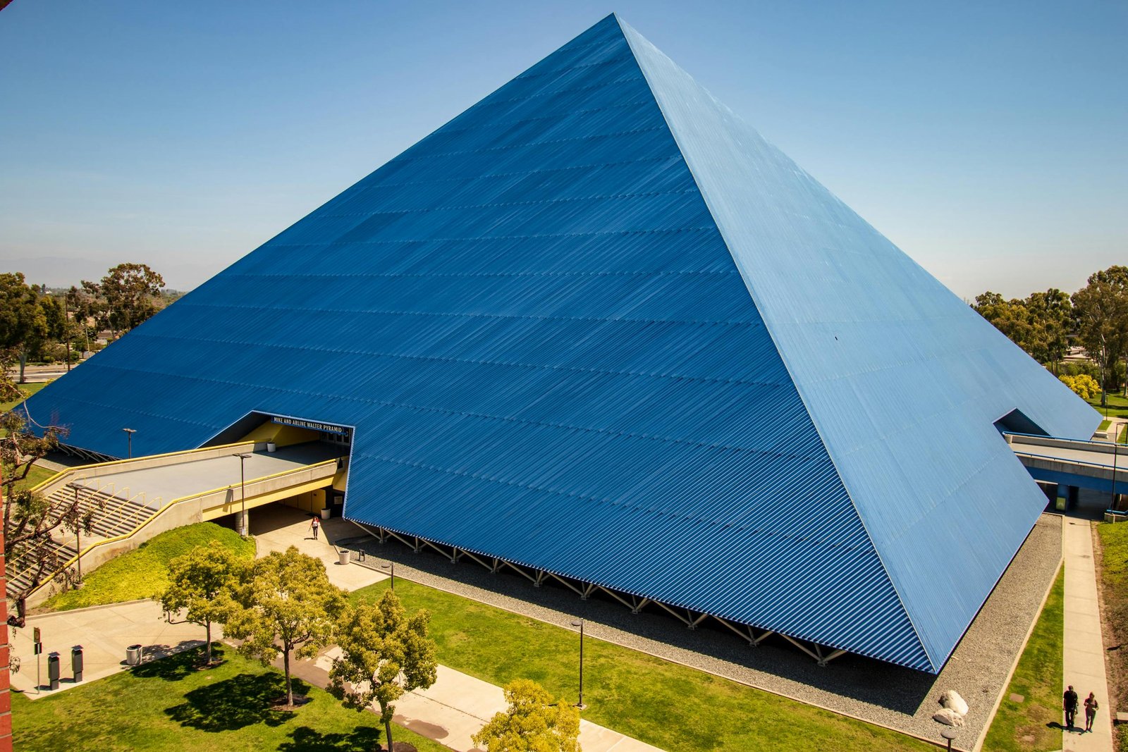 A Walter Retirement urban pyramid structure with blue exterior and lush surroundings.