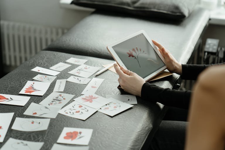 clickup application process finalizing floral tattoo designs on a digital tablet in a studio setting.