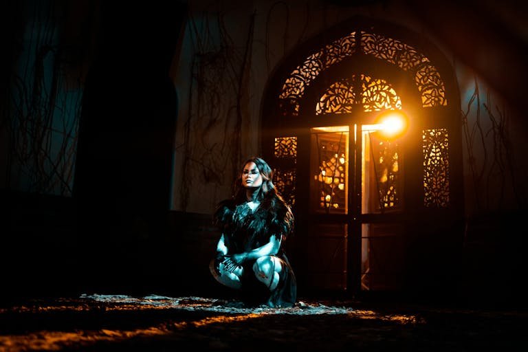 how to win in itmandoom17874 attire kneels in dramatic lighting with ornate door backdrop.