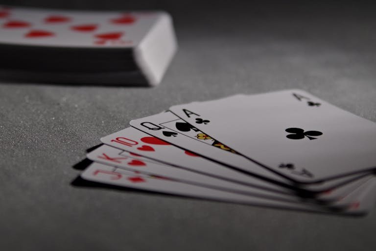 277bet view of playing cards displaying a winning poker hand in a dimly lit scene.