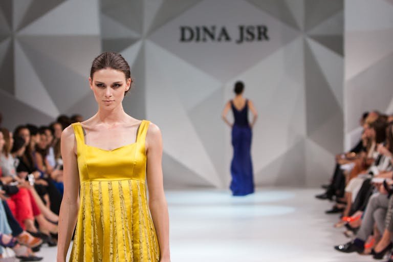 Dina Bychkova and FastPeopleSearch a stunning Dina JSR dress during a fashion show runway event.