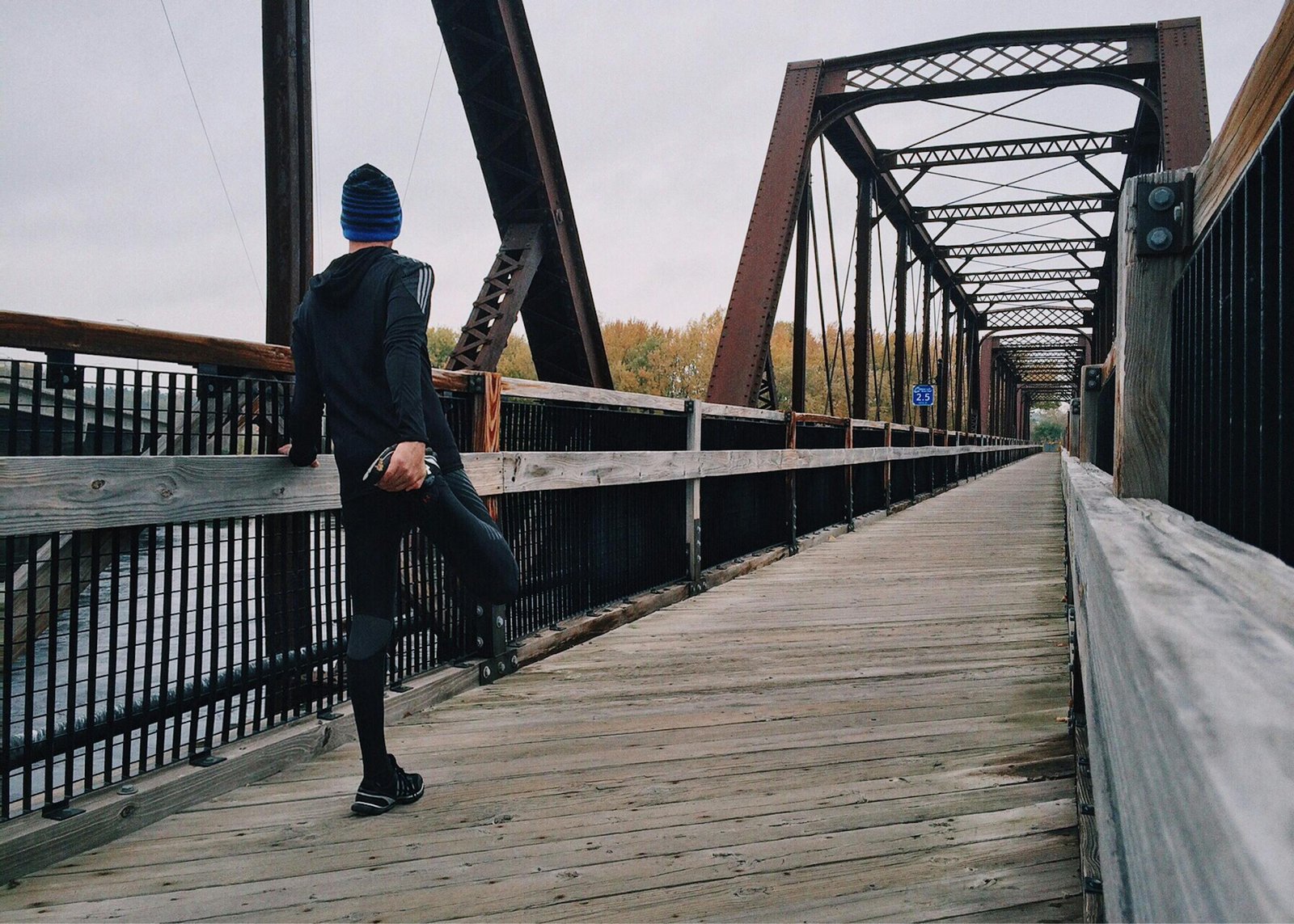 running man 中字/250705 e759 on a wooden footbridge during a daytime run on an iron bridge, emphasizing fitness and recreation.